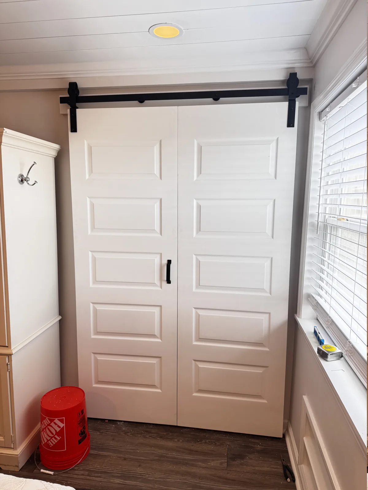 White double barn doors installed on black sliding hardware