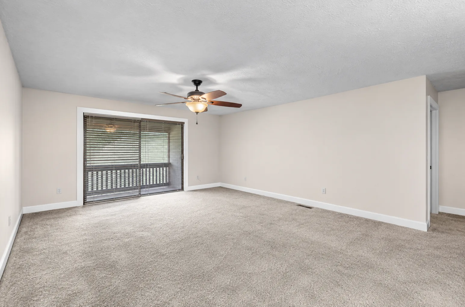Freshly painted living room corner with white baseboards and window trim