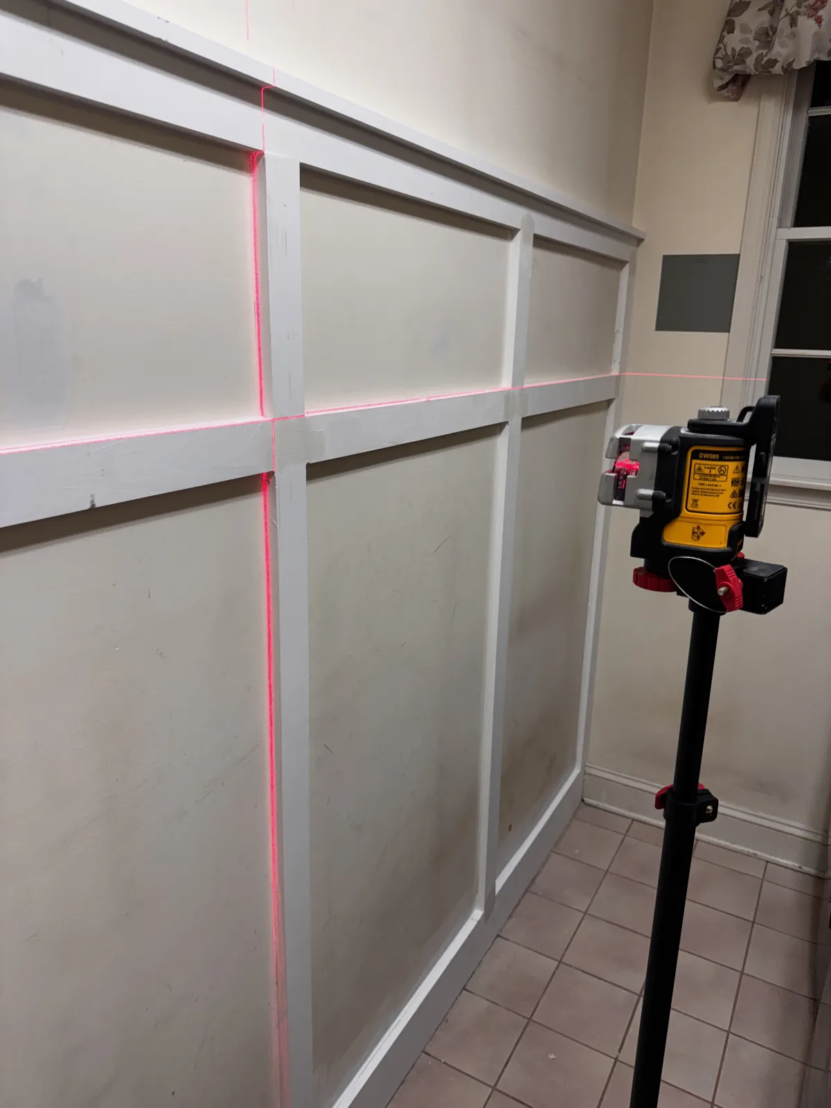 Panel molding being aligned with a laser level during a laundry room renovation