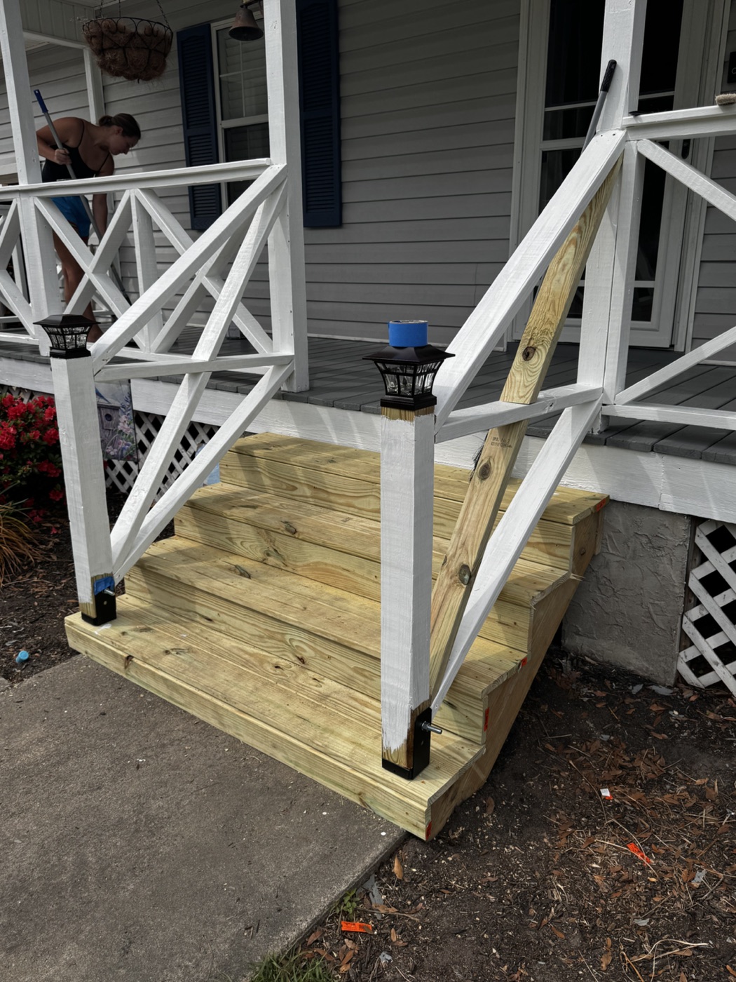 Painted porch railing detail over new wood stair rail