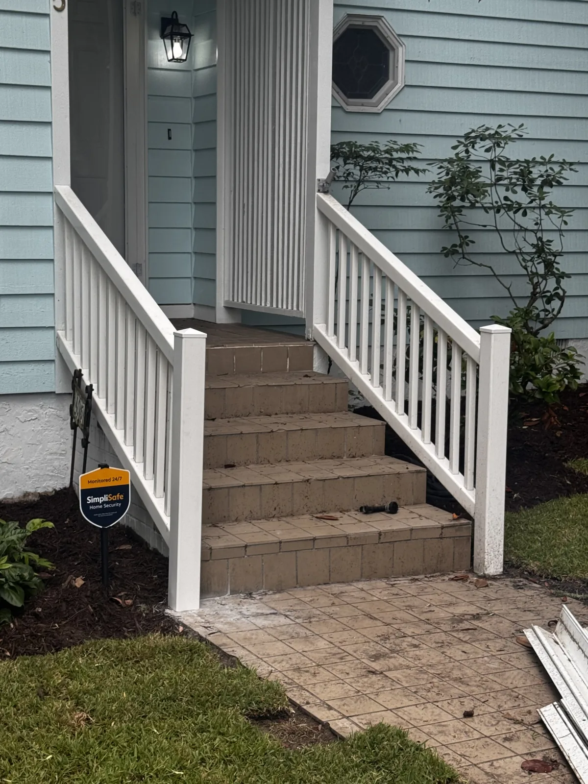 Repaired white porch railings around front entry steps
