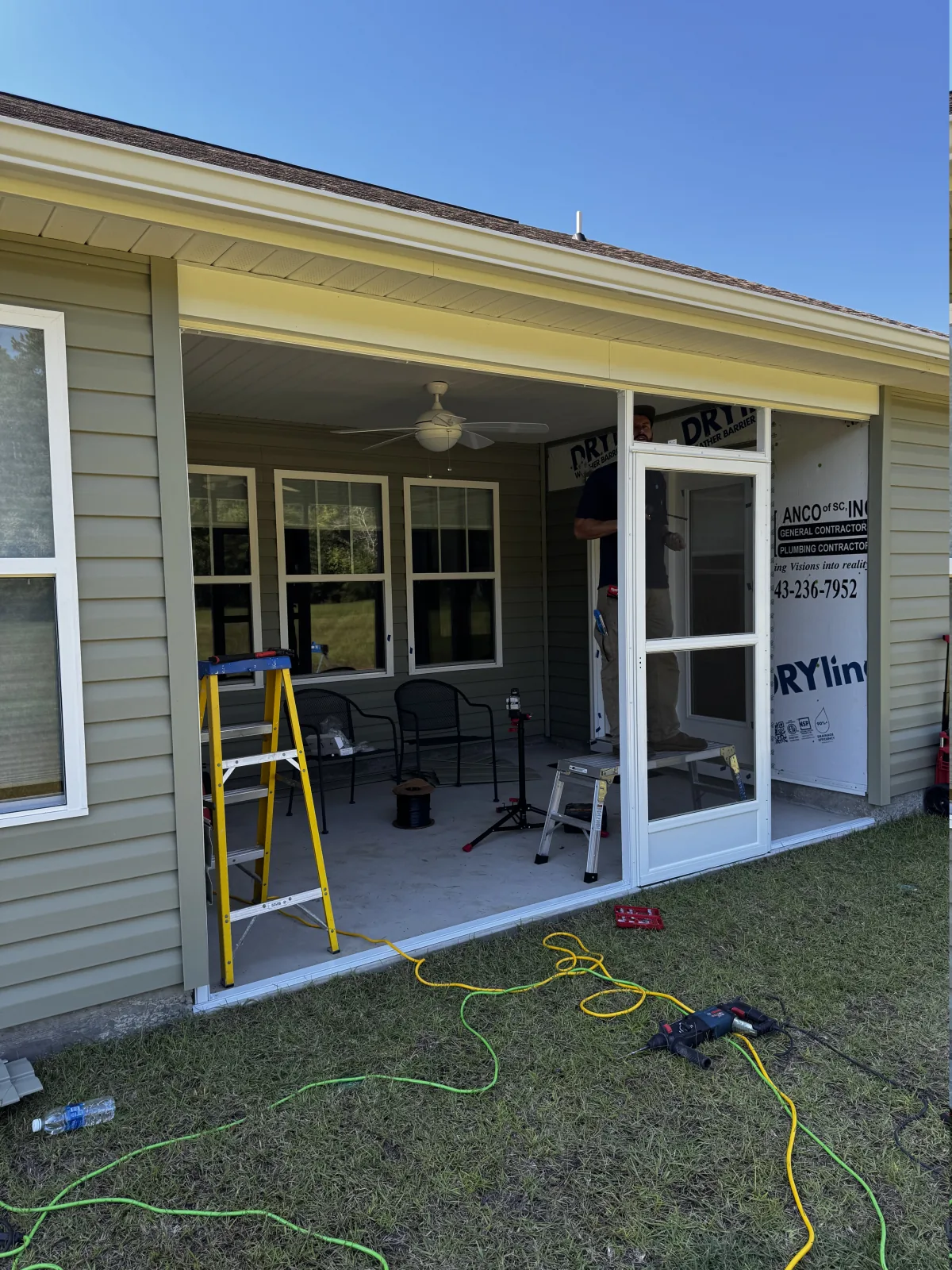 Screen door frame and porch enclosure taking shape during installation