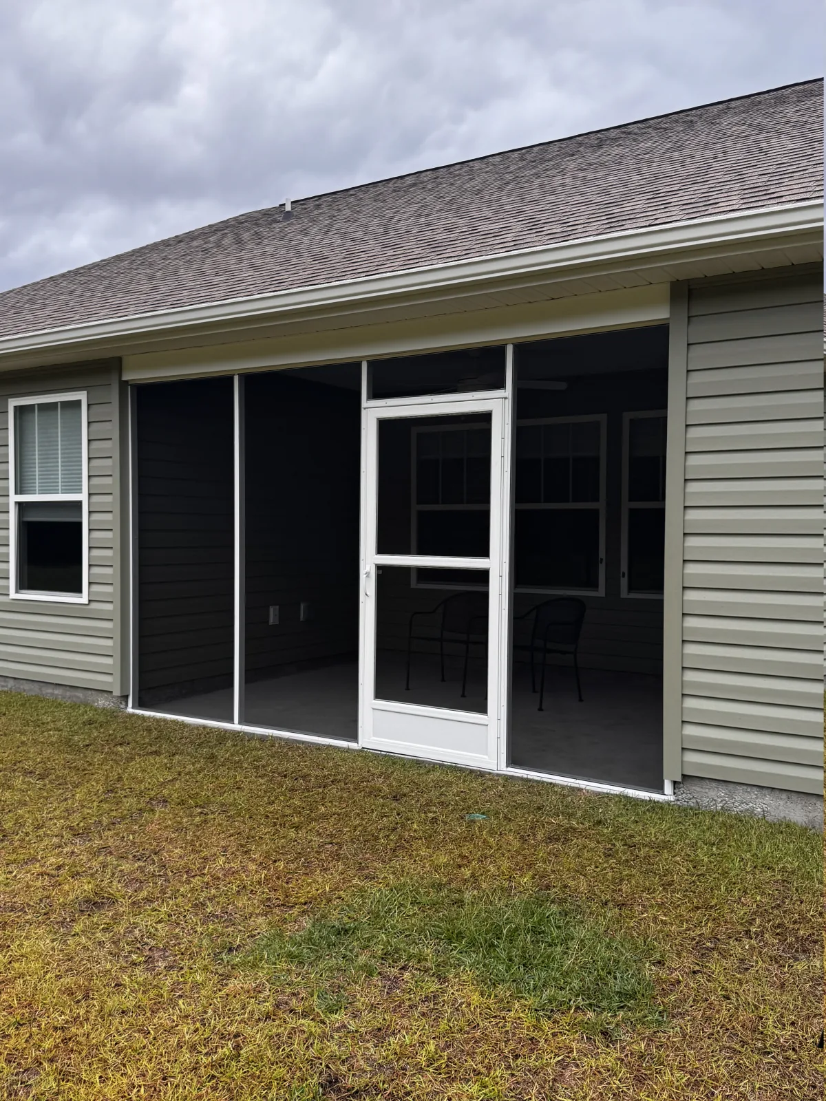 Completed screened porch enclosure with a centered screen door
