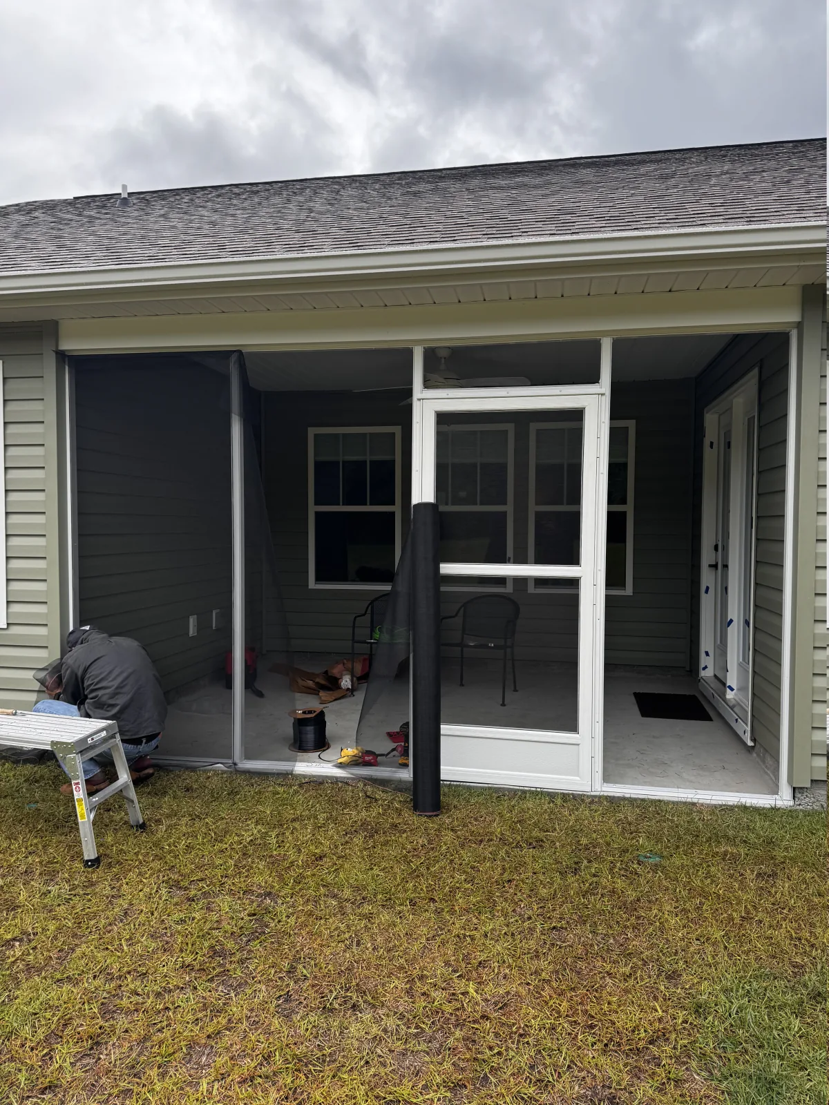 Screen mesh being installed across the framed porch openings