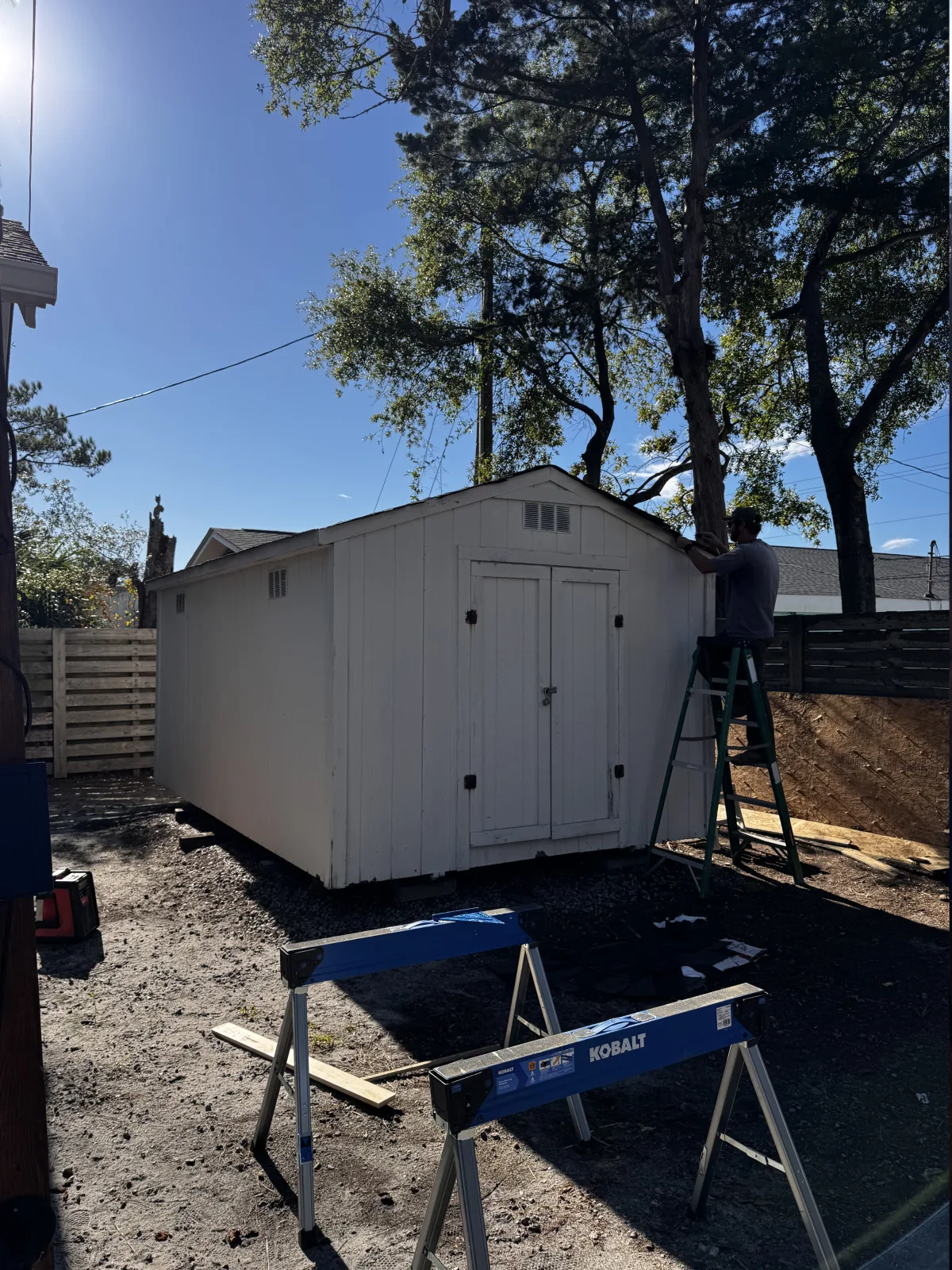 Exterior shed trim and roof-edge repair in progress